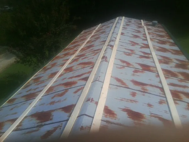 Rusted metal roof panels with new wood purlins before replacement — Storm Damage Roof Repair in Maitland by Roofing Brothers