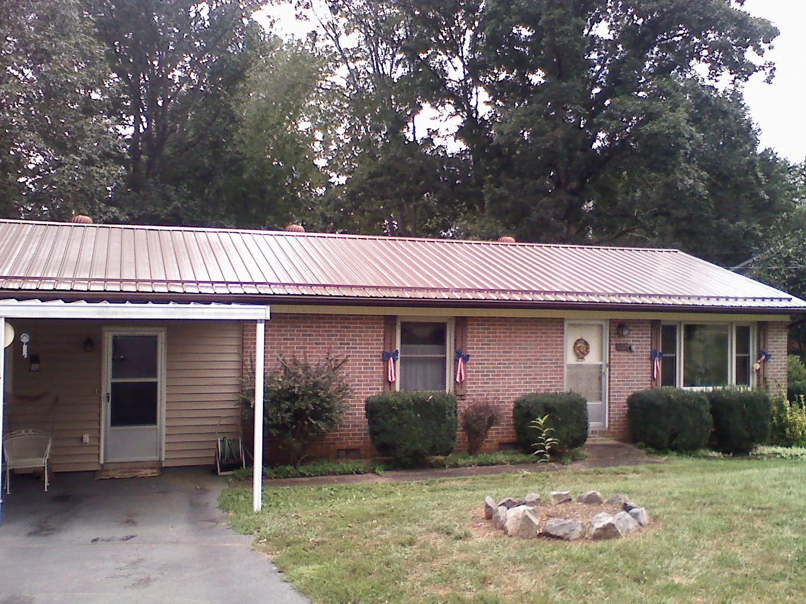 Bronze metal roof and carport on a brick ranch home — Roof Repair work by our crew in Maitland